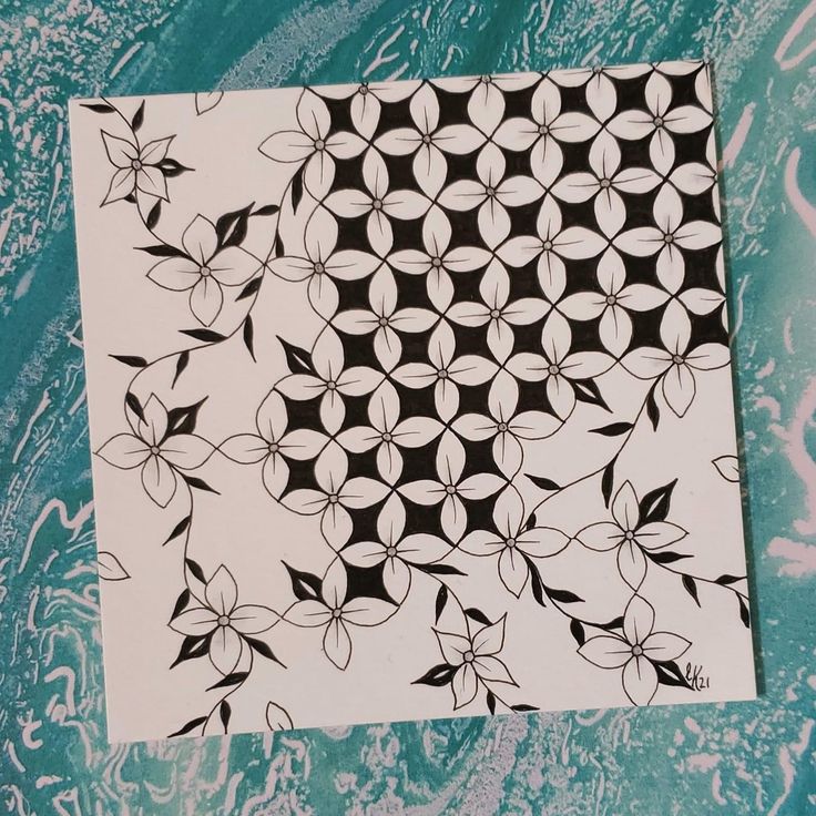 a piece of paper with black and white designs on it, sitting on a table