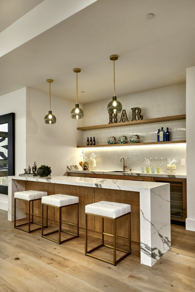 a kitchen with marble counter tops and bar stools