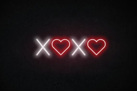 two heart shaped neon signs on a black background with the words xoxo written below them