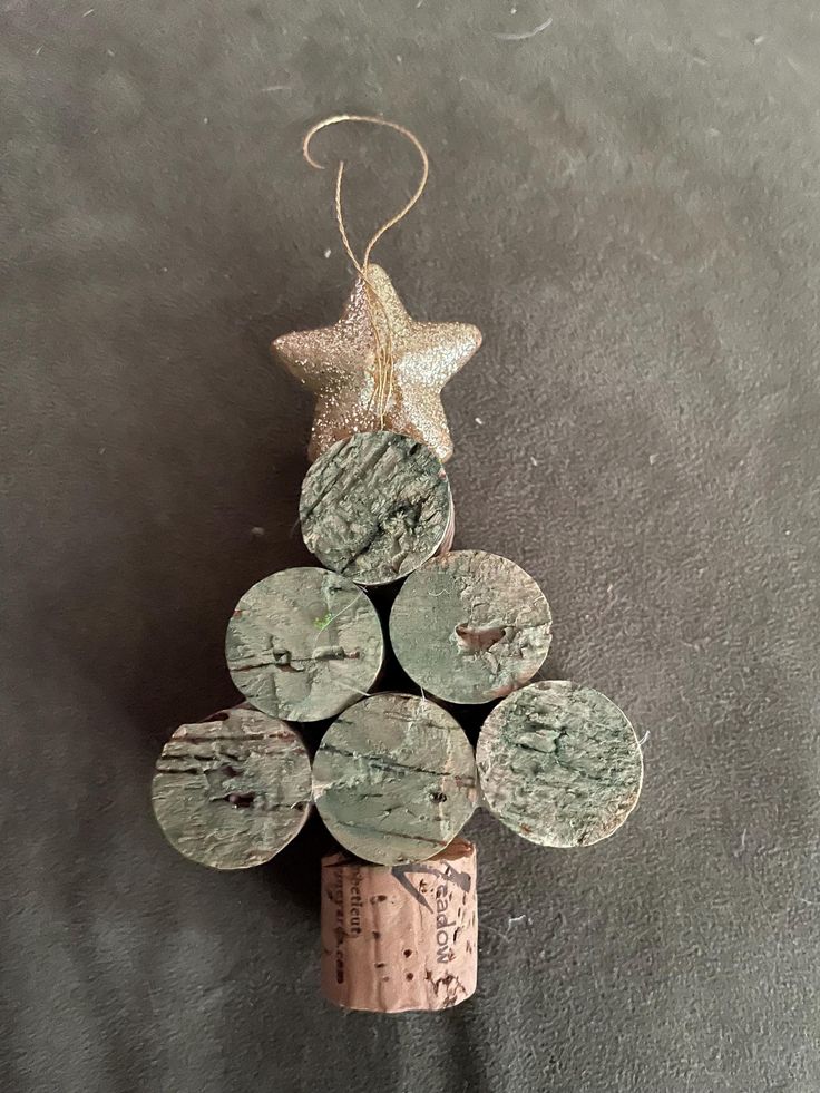 a small christmas tree made out of wine corks with a star hanging from the top