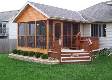 a house with a deck and covered patio in the grass next to a fenced yard