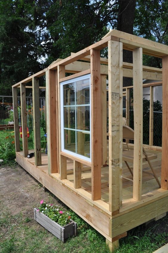 a small wooden structure with windows in it