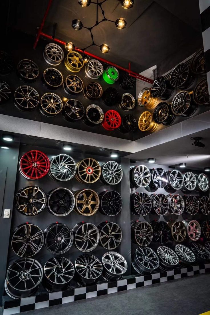 there are many different wheels on display in the room with checkered flooring and black and white walls