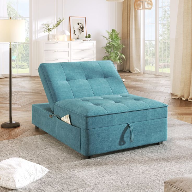 a blue futon bed sitting on top of a wooden floor next to a lamp