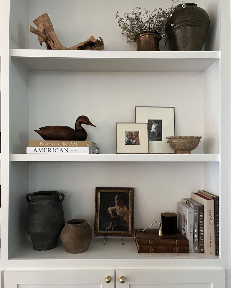 some shelves with pictures and vases on them