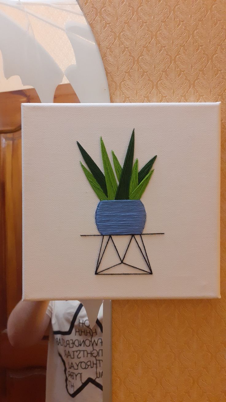 a card with an image of a plant in a blue pot on top of it