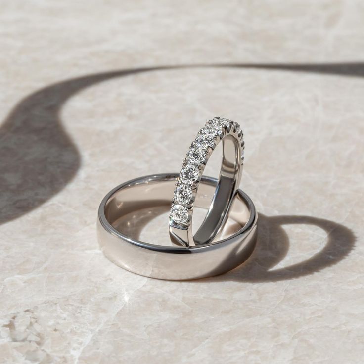 two wedding rings sitting on top of each other