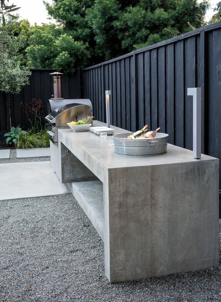 a concrete bench with food on it next to a fence