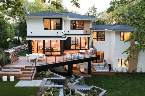 a large house that is surrounded by trees and lawn area with stairs leading up to the upper level