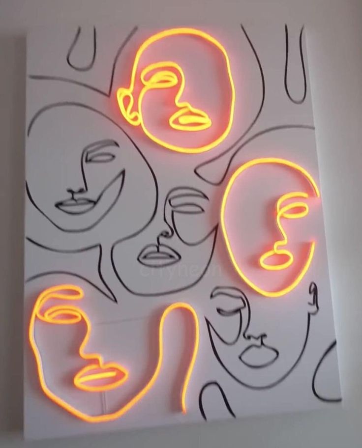 neon signs with faces on them in the shape of circles and lines, against a white wall