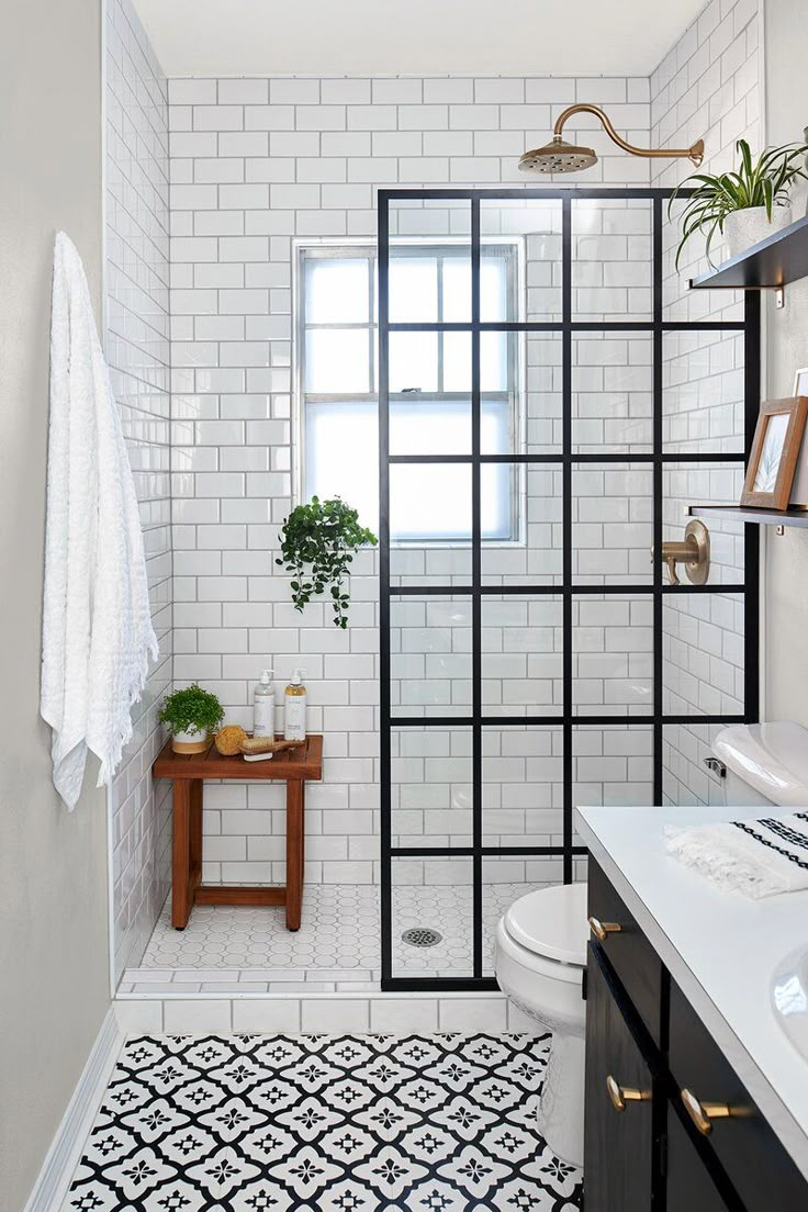 a white bathroom with black and white tiles