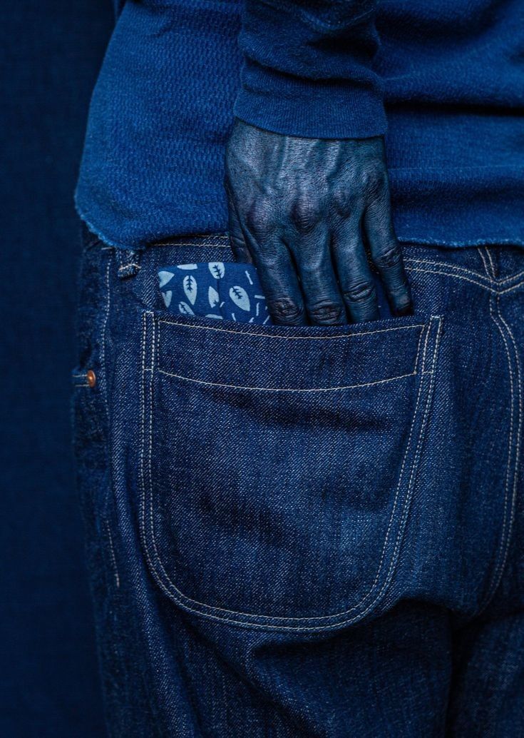 a person with their hand in the back pocket of his jean pants, which has an animal print on it