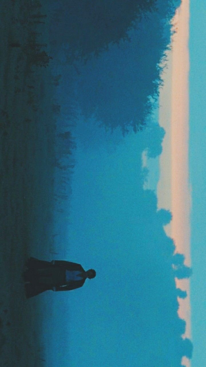 a person standing on the beach with their surfboard