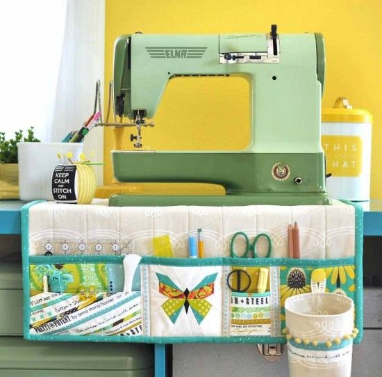 a sewing machine sitting on top of a blue table next to a potted plant