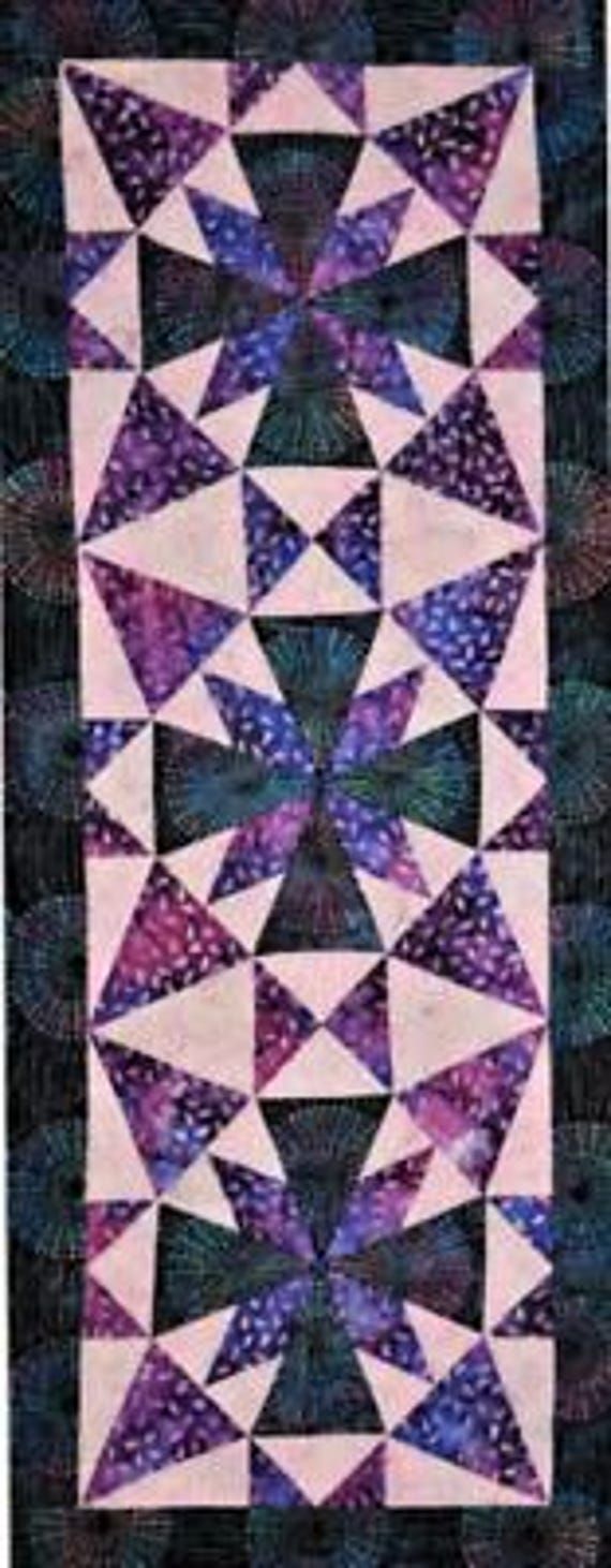 a purple and black quilt with triangles on it