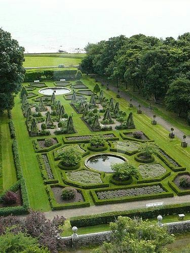 an aerial view of a formal garden with water in the center and trees surrounding it