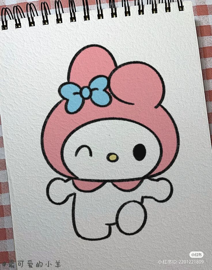 a drawing of a hello kitty with a bow on it's head, sitting in front of a checkered tablecloth