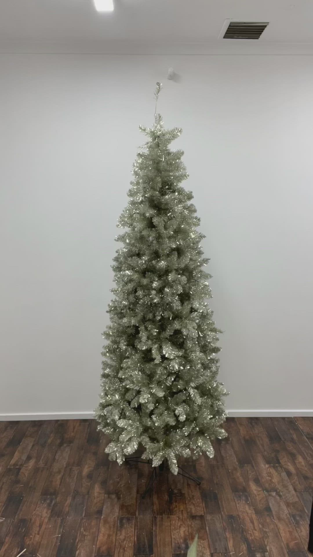 This may contain: a woman is decorating a christmas tree with red, white and green flowers on it