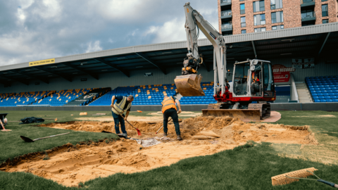 Workmen excavate the pitch at Plough Lane