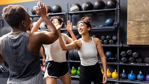 Three women high-fiving in gym (Credit: Getty Images)