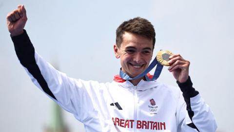 Alex Yee holds his Olympic gold medal