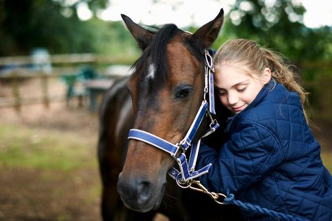 Vaterliebe: Ein Mädchen schmust mit seinem Pferd