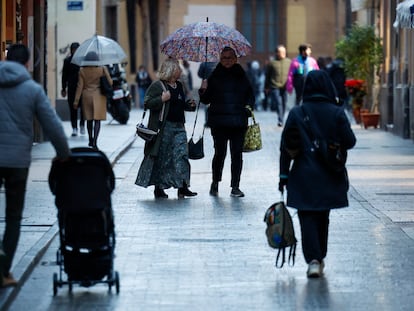 Varias personas caminan bajo la lluvia en Valencia. 