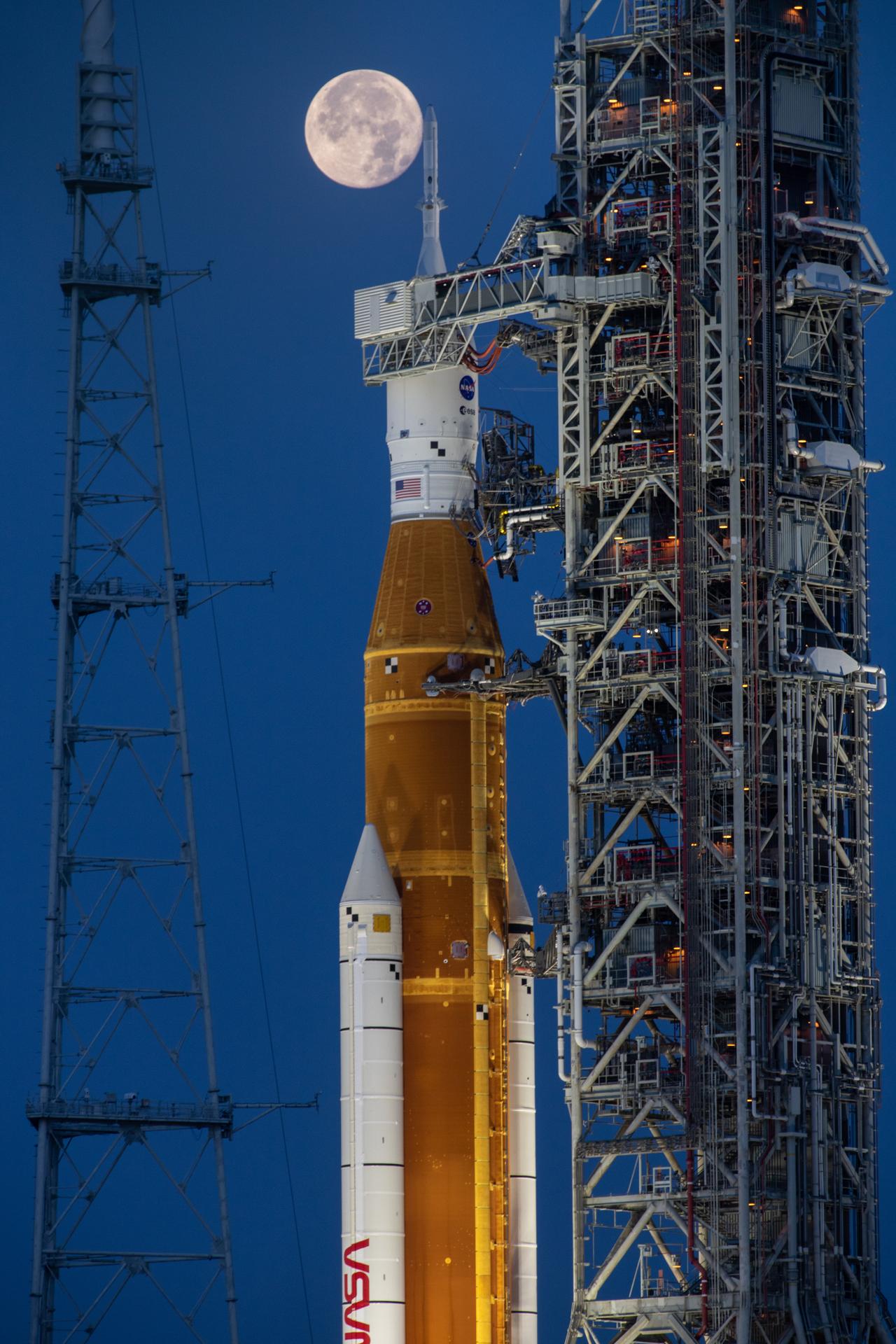 Artemis 1 on launch pad with moon in the background