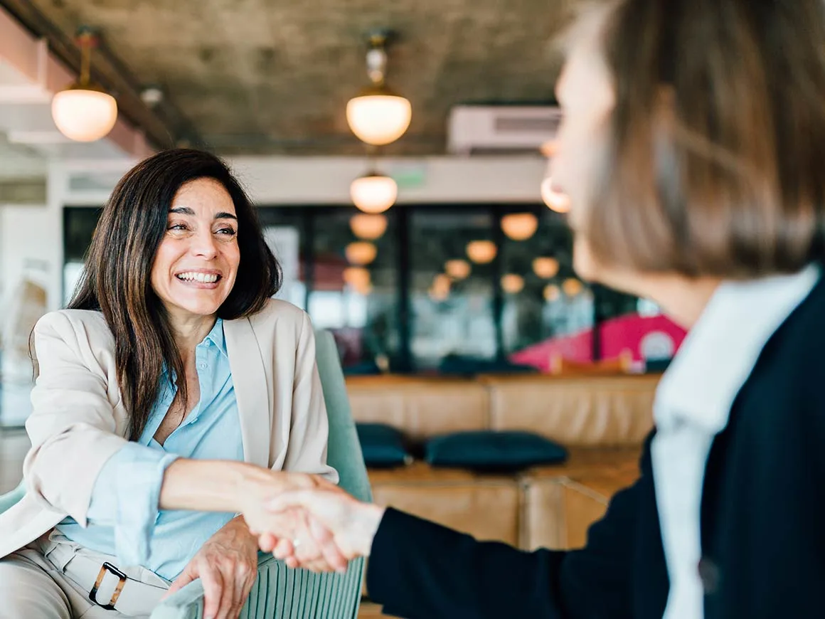 Two business women shaking hands