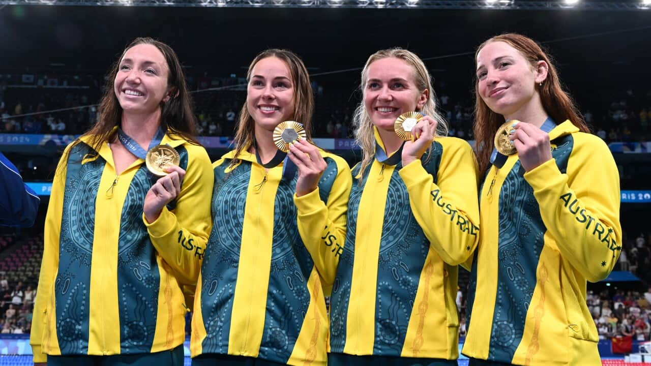 Four female athletes show their medals.