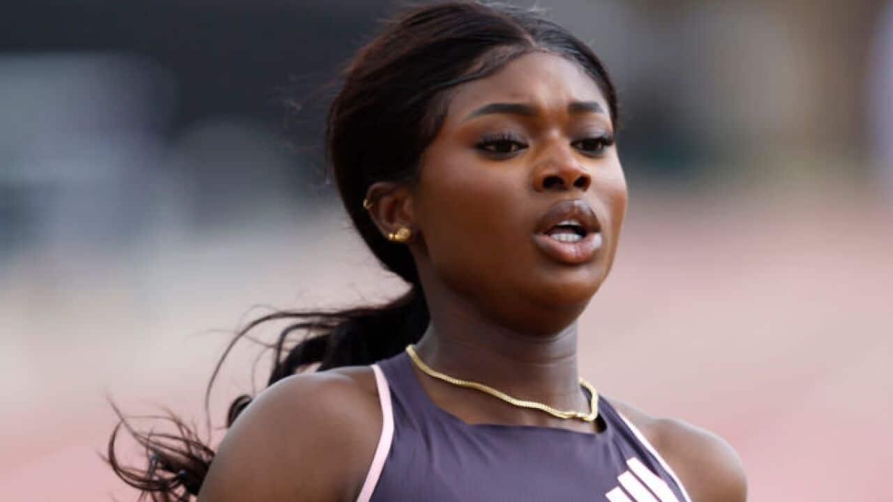 A female sprinter competes on the track.