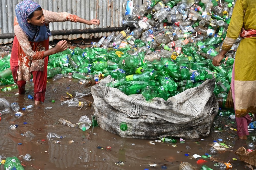 Two women collecting bottles