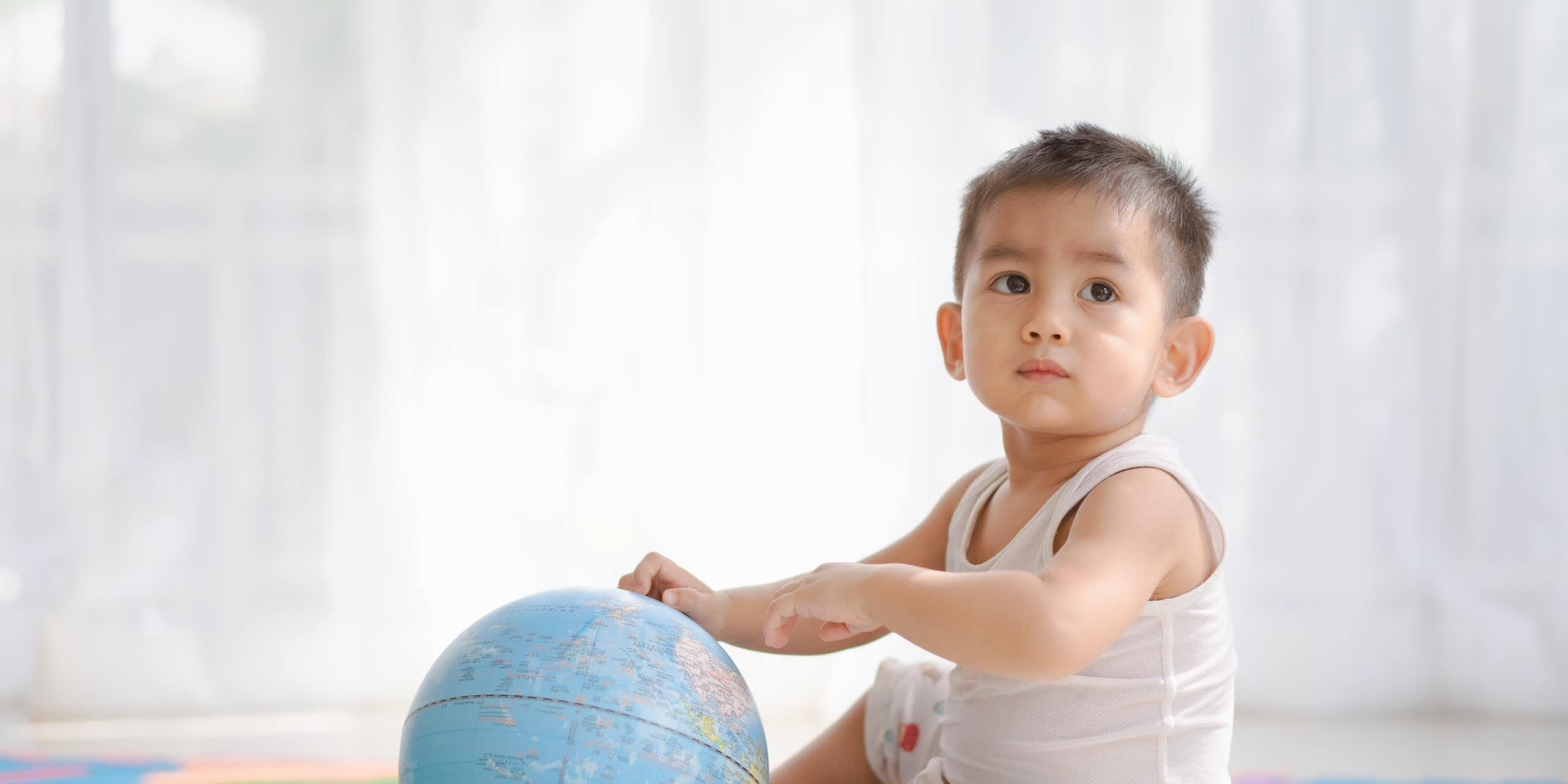 Un enfant tient un globe terrestre.