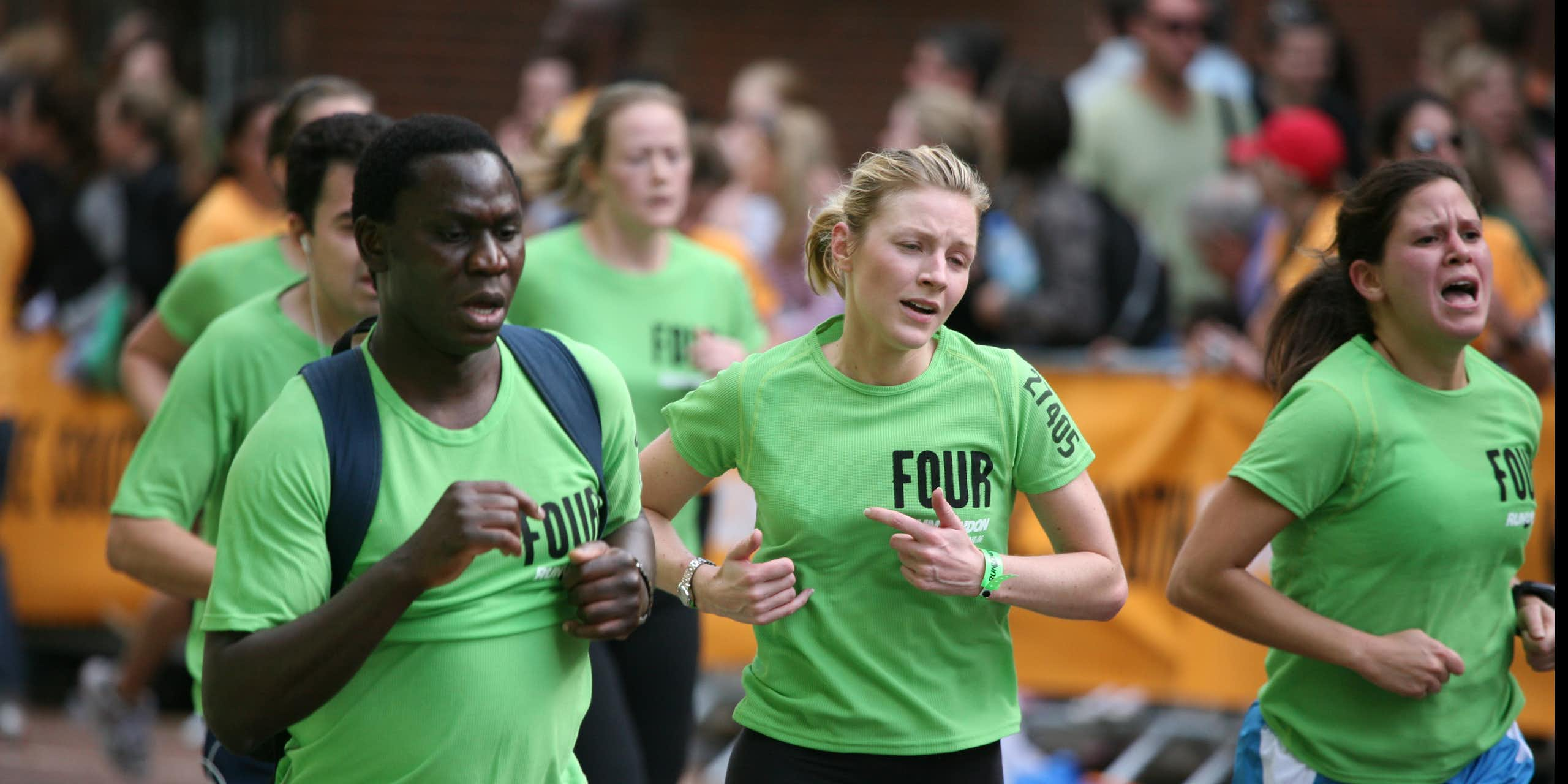 Un homme et deux femmes en train de courir en grimaçant.