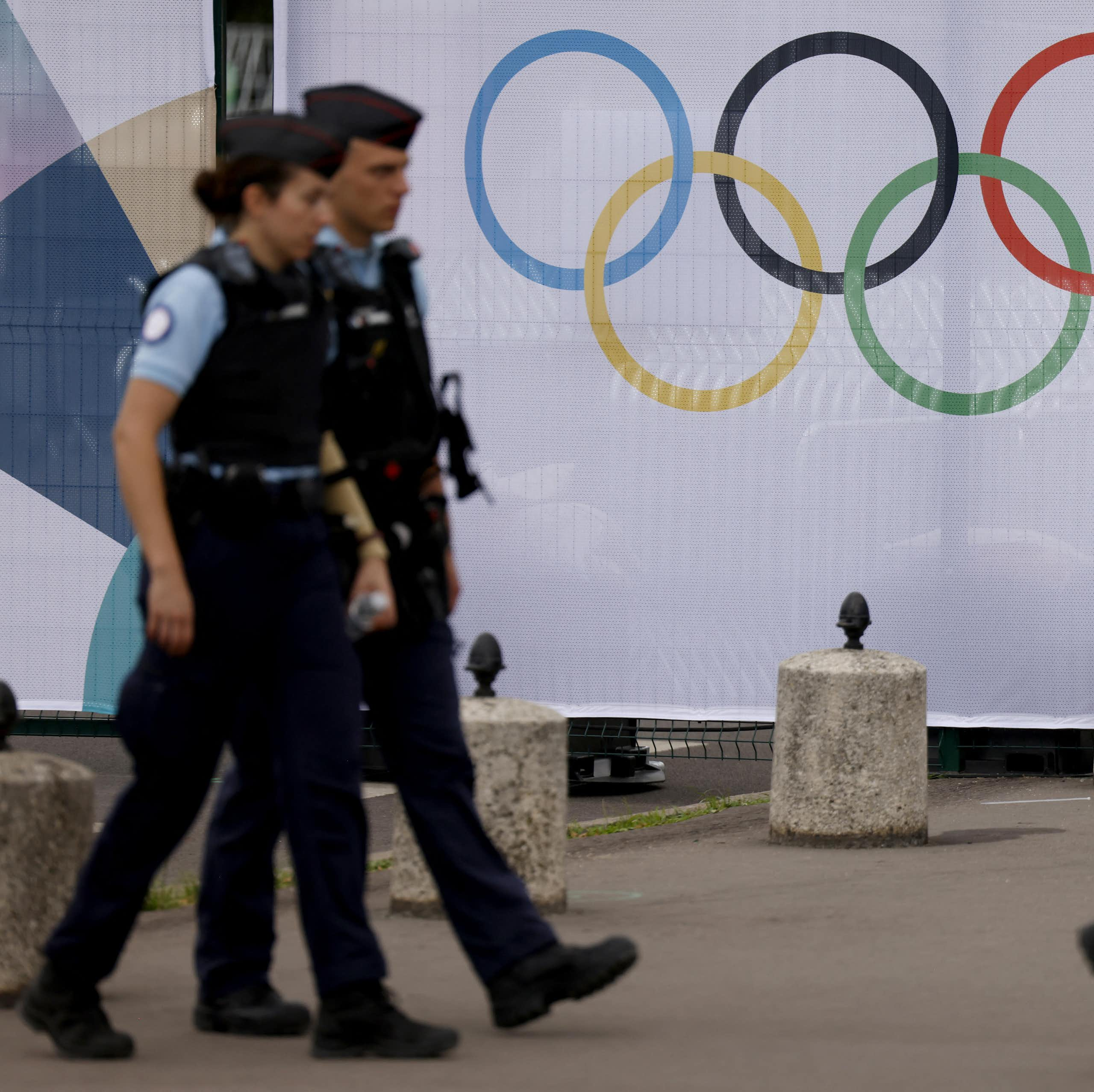 Des gendarmes français patrouillent le long des clôtures bordant le site olympique des Invalides à Paris, le 16 juillet 2024.