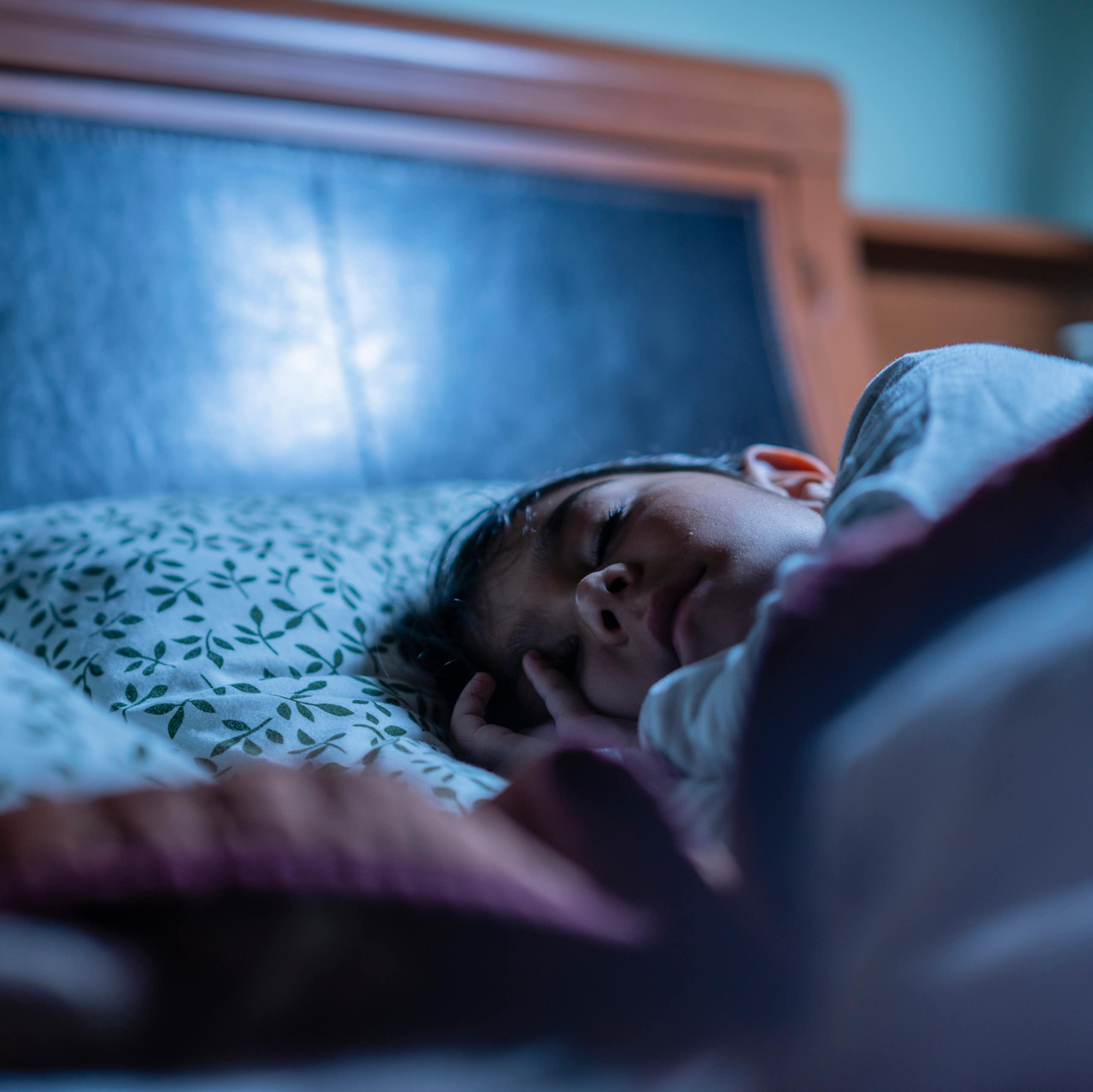 Un enfant dormant dans un lit.