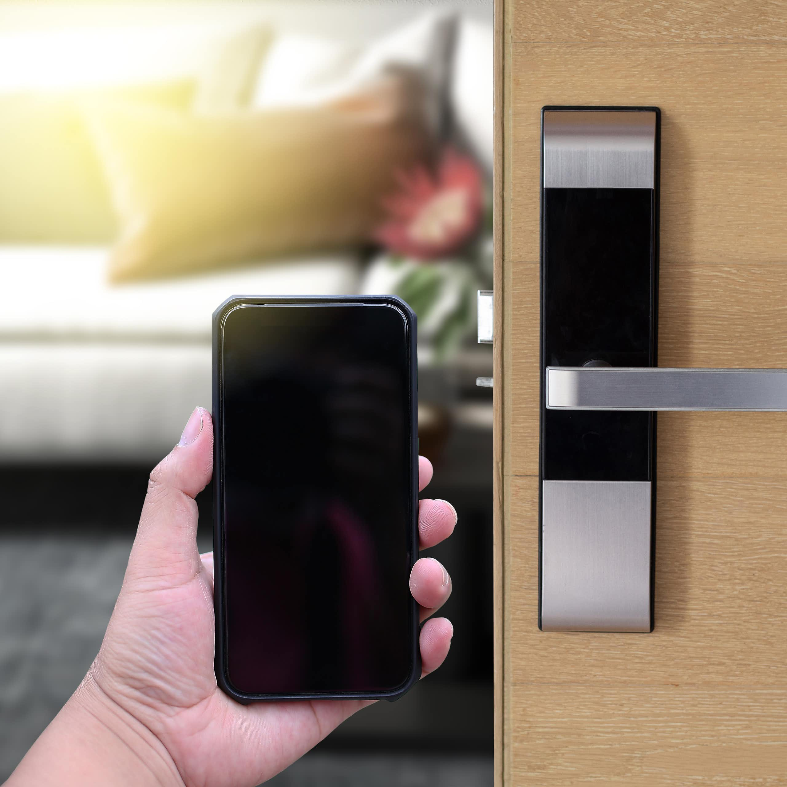 Une personne ouvre la porte d'une chambre d'hôtel avec son smartphone