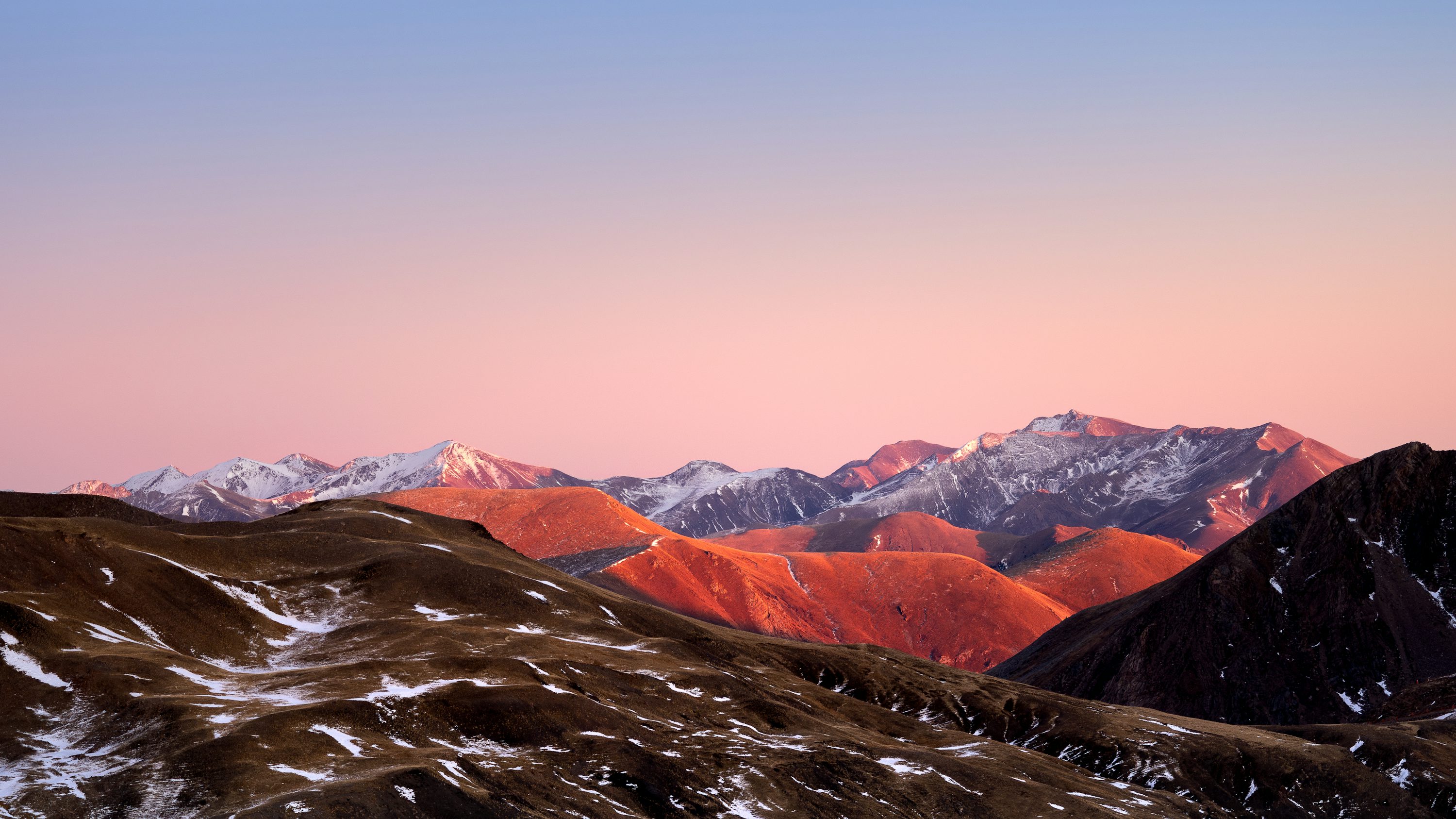 A mountain range with snow covered mountains in the background