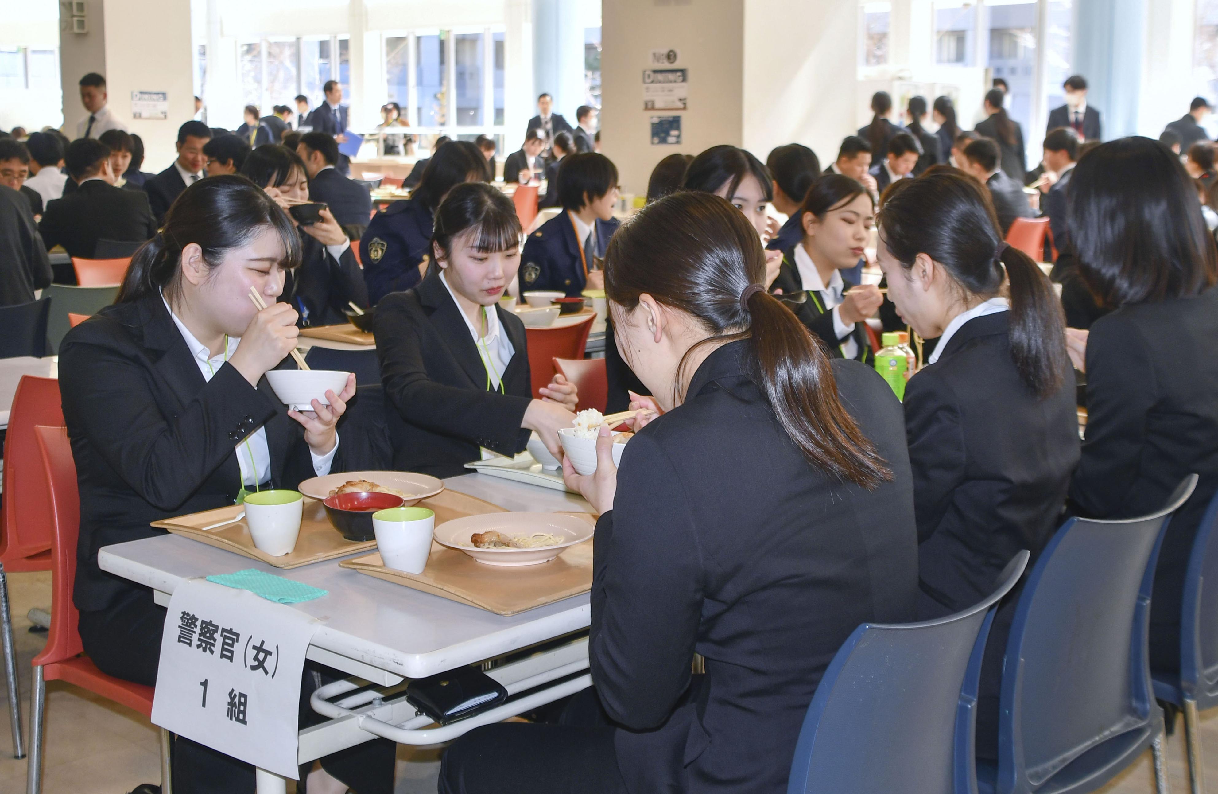 警視庁警察学校の食堂で食事をする入庁予定者ら＝15日正午ごろ、東京都府中市