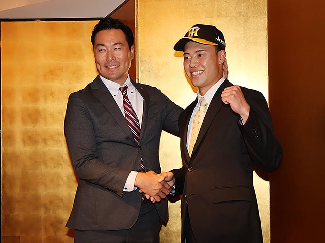 ガッツポーズする佐野と筒井スカウト（左）