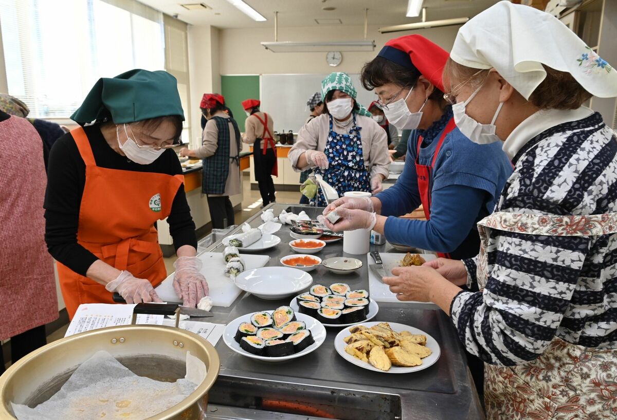 レシピ集を参考に調理する参加者