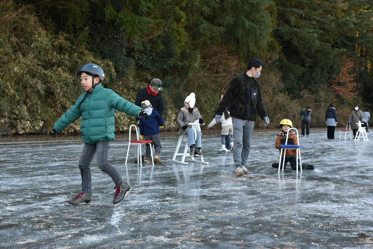 天然氷のリンクでスケートを楽しむ親子連れ