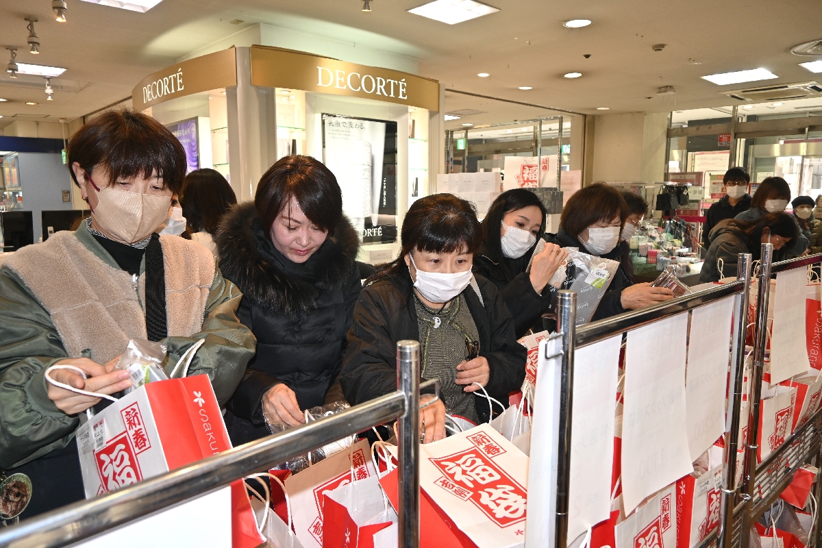 中身を品定めしながら、福袋を買い求める来店客＝１日午前１０時４０分ごろ、さくら野百貨店八戸店