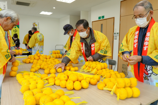 ゆず湯セットを作る宇佐柚子生産組合の生産者ら＝宇佐市院内町山城のＪＡおおいた院内出張所