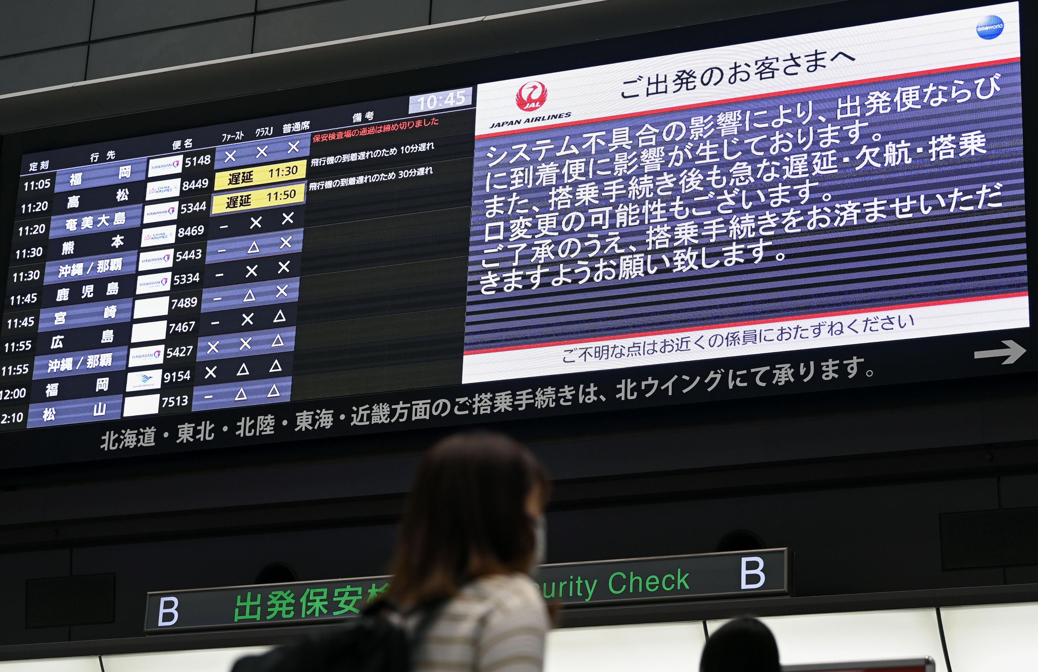 システムの不具合を伝える日航の電光掲示板＝26日午前、羽田空港