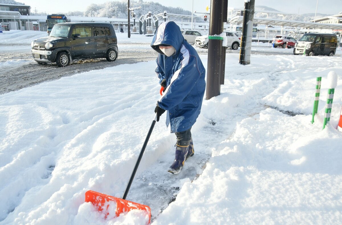 ＪＲ三次駅前の国道１８３号沿いで雪かきをする市民＝10日午前８時５分（画像の一部を修整しています）