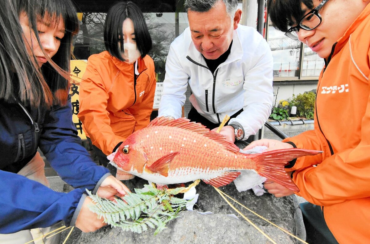 タイのオブジェを清掃し、しめ縄を取り付ける関係者＝２７日、境港市花町