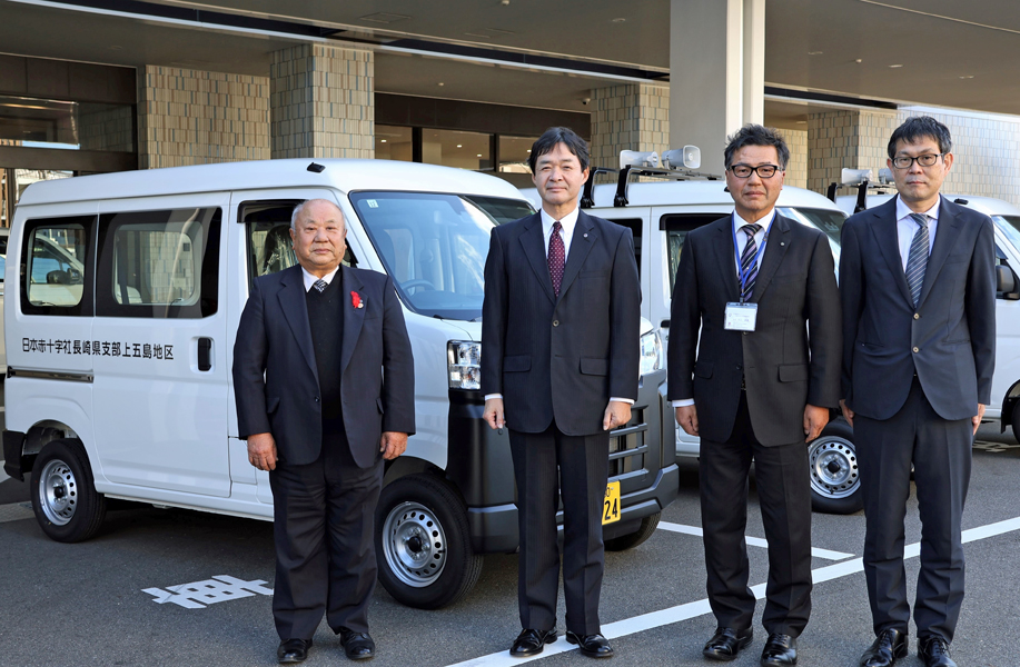 園田事務局長（左から２番目）から災害救援車の引き渡しを受けた代表者の３人＝長崎市、日本赤十字社県支部