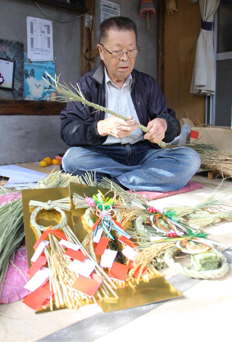 丁寧に縄をなう「ささかみしめ飾り部会」の五十嵐繁部会長＝阿賀野市笹神地区