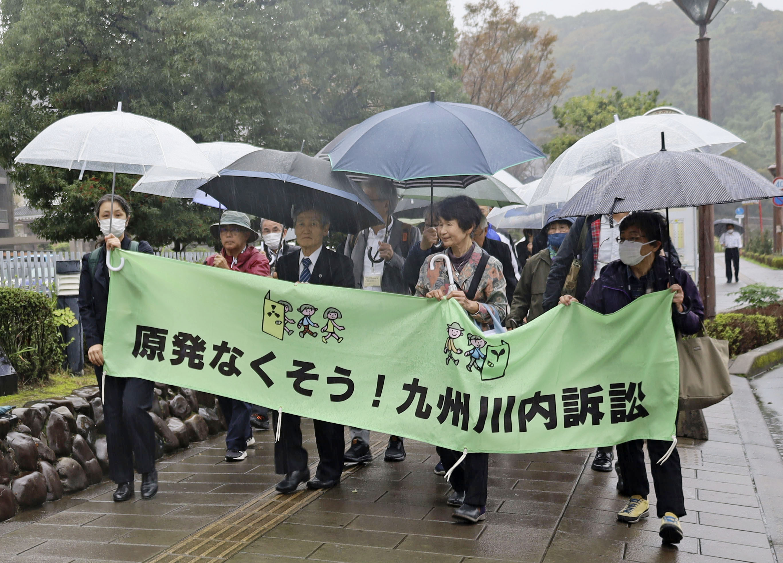 九州電力川内原発の運転差し止めを求めた訴訟の口頭弁論のため、鹿児島地裁に入る原告団ら＝26日午後